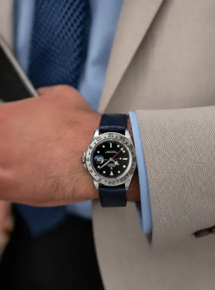 Dark blue leather watch strap by vild Hamburg on a Rolex Explorer II 16570 Black on the wrist of a man wearing a light jacket and light blue shirt.