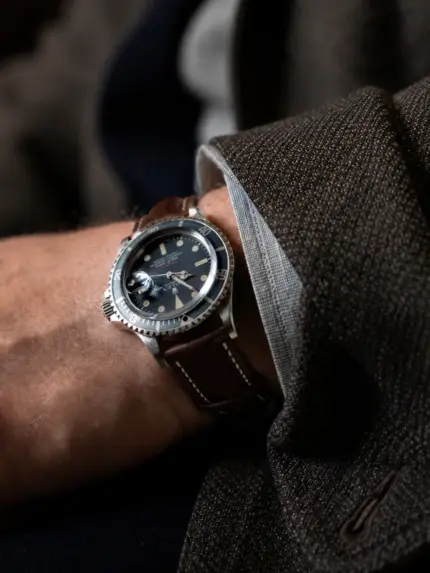 Leder Uhrarmband in Dunkelbraun von vild Hamburg an vintage Rolex Sea-Dweller am Handgelenk Mann mit dunkelbrauner Jacke und grauem Hemd