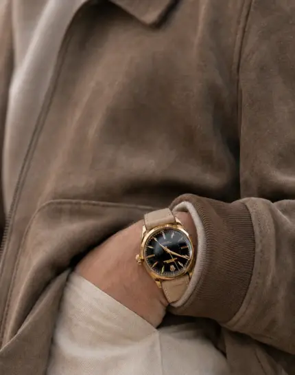 Beige suede watch strap from vild Hamburg worn on a vintage gold Rolex Oyster on the wrist with a grey-brown nubuck leather jacket and light chinos